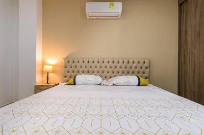 a bedroom with a large bed with a white comforter at Makadamia Aptos in Sincelejo