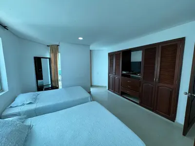 a hotel room with two beds and a television at Apartamento en Laguito Ed Torres del Lago 604 ICDI in Cartagena de Indias