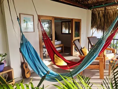 a room with two hammocks in a house at Deluxe Family Suite - In front of the sea in Moñitos