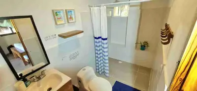 a bathroom with a shower and a sink and a mirror at Deluxe Family Suite - In front of the sea in Moñitos