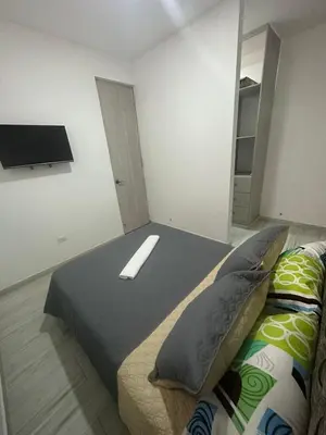 a bedroom with a bed and a tv on the wall at Campiña Stay Apartamento Amoblado in Cartagena de Indias