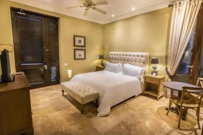 a bedroom with a large white bed and a chair at Bastión Luxury Hotel in Cartagena de Indias