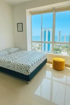 a bedroom with a bed and a large window at Lindo apto vista al mar,central y piscina rooftop in Cartagena de Indias