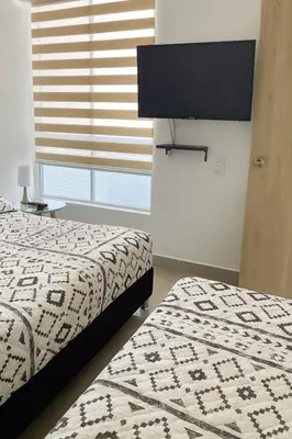 a bedroom with a bed and a flat screen tv at Lindo apto vista al mar,central y piscina rooftop in Cartagena de Indias