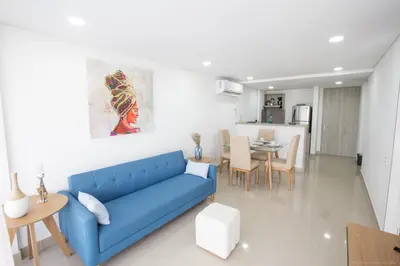 a living room with a blue couch and a table at Confortable Apartamento Ocean Drive 711 -estancia mínima 2 noches- in Cartagena de Indias