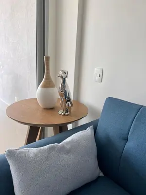 a table with a vase on it next to a blue couch at Confortable Apartamento Ocean Drive 711 -estancia mínima 2 noches- in Cartagena de Indias
