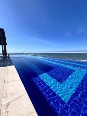 a swimming pool with the ocean in the background at Confortable Apartamento Ocean Drive 711 -estancia mínima 2 noches- in Cartagena de Indias