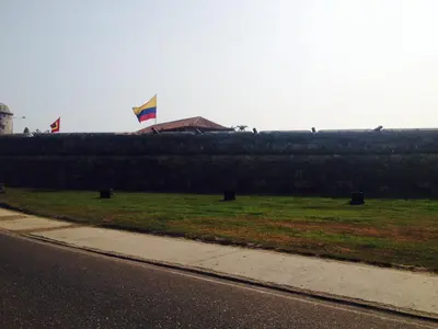 a fence with two kites flying over a field at Apartamento con vista al laguito y al mar in Cartagena de Indias