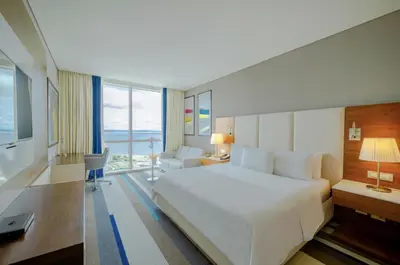 a hotel room with a large white bed and a desk at Hotel InterContinental Cartagena by IHG in Cartagena de Indias