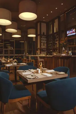 a restaurant with wooden tables and blue chairs at Hotel InterContinental Cartagena by IHG in Cartagena de Indias