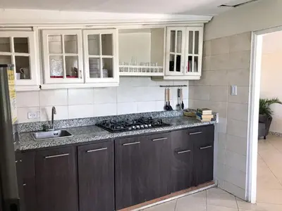 a kitchen with white cabinets and a sink and a counter at Casa Hotel Terraza del Cabrero in Cartagena de Indias