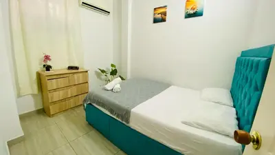 a small bedroom with a blue bed and a dresser at Casa Hotel Terraza del Cabrero in Cartagena de Indias