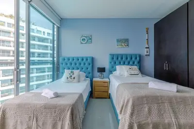 two beds in a room with blue walls at Espectacular apartamento en Cartagena Seaway935 - Morros in Cartagena de Indias