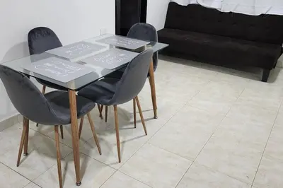 a table with three chairs and a table and a couch at Lindo Apartamento cerca al Estadio Metropolitano in Barranquilla