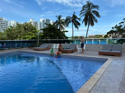 a woman standing next to a swimming pool at Hermoso apartamento con vista al mar in Cartagena de Indias