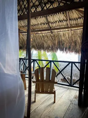 a chair on a deck with a view of the ocean at Palenque Beach House in San Onofre