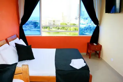 a bedroom with a bed and a large window at Studio Apartment E11C Near The Sea With Pool in Cartagena de Indias