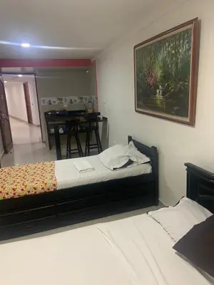 a bedroom with a bed and a table in it at Studio Apartment E11C Near The Sea With Pool in Cartagena de Indias