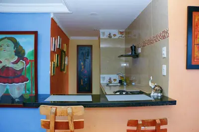 a kitchen with a counter and two chairs in it at Apartment 1C11 Near The Sea With Pool in Cartagena de Indias