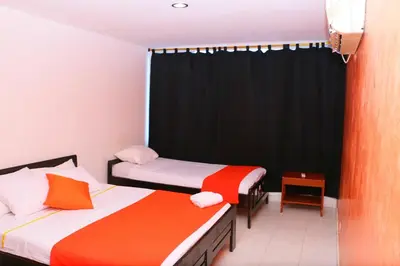 a bedroom with two beds and a black curtain at Apartment 1C19 Close To The Sea With Pool in Cartagena de Indias