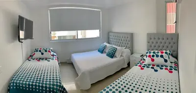 a small bedroom with two beds and a mirror at Apartment al-2 facing the sea with Wifi in Cartagena de Indias