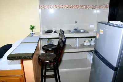 a kitchen with a refrigerator and a counter with two stools at Studio Apartment E19C Close To The Sea And Pool in Cartagena de Indias