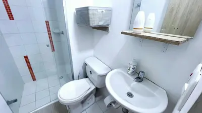 a white bathroom with a toilet and a sink at Aqualina 42M2/3 cuadras playa in Cartagena de Indias