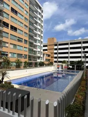 a swimming pool in front of a large building at Apartamento en Barranquilla Zona Norte Miramar in Barranquilla