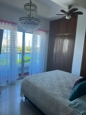 a bedroom with a bed with a ceiling fan and a window at Exquisite apartment in El Laguito Cartagena in Cartagena de Indias