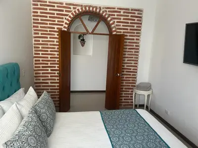 a bedroom with a bed and a brick wall at Exquisite apartment in El Laguito Cartagena in Cartagena de Indias