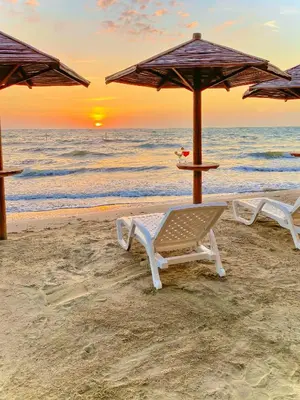 two beach chairs and an umbrella on the beach at Suite privada frente al mar, Tolú in San Silvestre