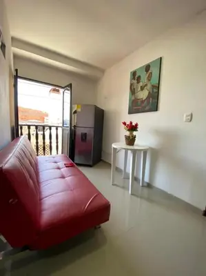 a living room with a red couch and a refrigerator at 3 bedroom apartment 3CL3 in the old center in Cartagena de Indias