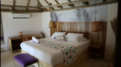 a bedroom with a bed and a purple chair at Hotel Rosario de Mar by Tequendama in Isla Grande