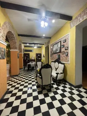 a living room with chairs and a checkered floor at hotel san nicolas colonial in Barranquilla