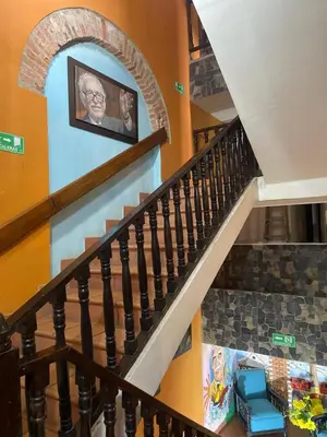a staircase with a picture of a man on the wall at hotel san nicolas colonial in Barranquilla