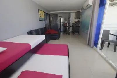 a hotel room with a bed and a living room at Apartamentos Bacanos in Cartagena de Indias