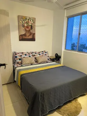 a bedroom with a bed with a painting on the wall at Boho style house in Cartagena de Indias