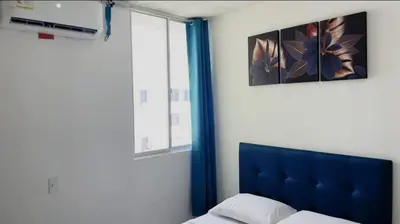 a bedroom with a blue headboard and a window at Apartamento Amoblado Cartagena in Cartagena de Indias