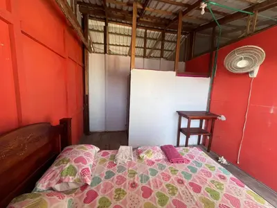 a bedroom with a bed in a red room at Hostal Paraiso in Isla Mucura