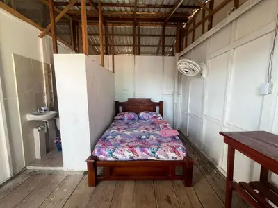 a bedroom with a bed in the corner of a room at Hostal Paraiso in Isla Mucura