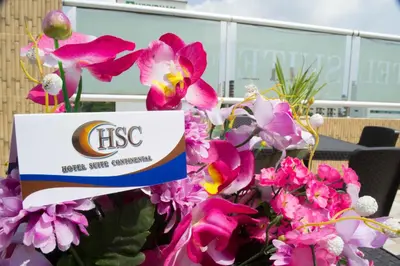 a sign in a bunch of pink flowers at Hotel Suite Continental in Barranquilla