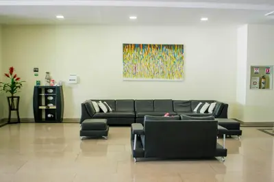 a living room with a black couch and chairs at Hotel Suite Continental in Barranquilla