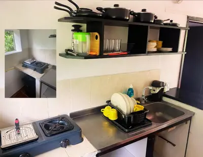 a kitchen with a sink and a stove with pots and pans at Apartamentos Sol de Coveñas TI in Coveñas