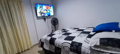 a bedroom with a bed and a flat screen tv at Apto los Almendros in Cartagena de Indias