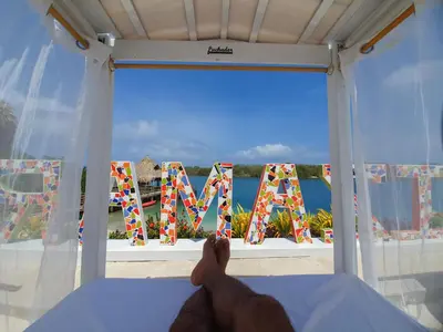 a person laying on a bed looking out a window with the word vacation at Hotel Isla Lizamar in Isla Grande