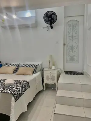 a white room with two beds and a door at Alojamiento vacacional en Bocagrande Cartagena in Cartagena de Indias