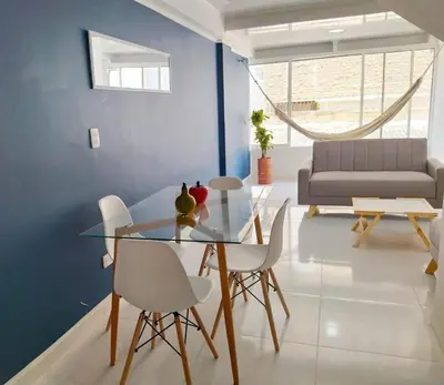 a dining room with a glass table and white chairs at Apartamento Marbella - En Edificio Frente a la Playa cerca al centro Histórico in Cartagena de Indias