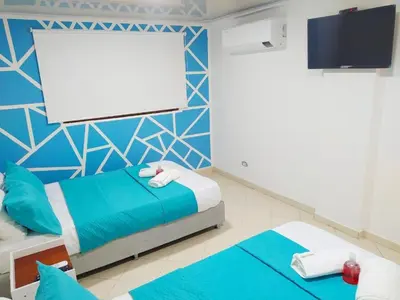 a bedroom with two beds and a blank screen at Apartamento Marbella - En Edificio Frente a la Playa cerca al centro Histórico in Cartagena de Indias