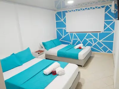 a bedroom with two beds and a blank screen at Apartamento Marbella - En Edificio Frente a la Playa cerca al centro Histórico in Cartagena de Indias