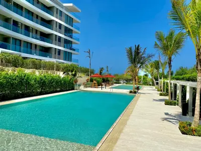 a swimming pool with palm trees and a building at Morros Zoe - Beautiful Apartment on Manzanillo Beach in Cartagena de Indias
